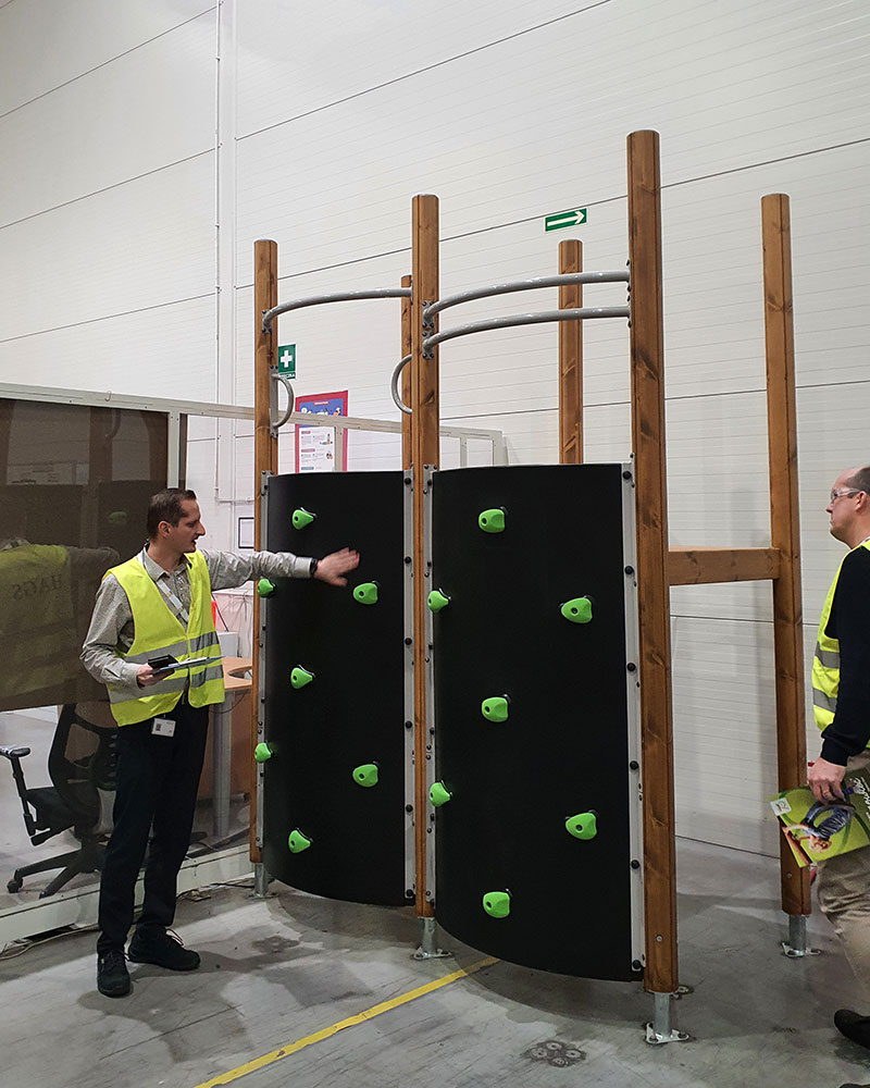 A warehouse manager demonstrating wooden playground equipment at the warehouse.